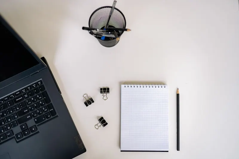 Checkliste mit Stift neben einem Laptop bei der Planung